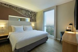 Giường trong phòng chung tại Swiss-Belinn Saripetojo Solo