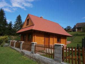 une petite maison en bois avec une clôture en bois dans l'établissement Drevenica Silvia, à Liptovský Mikuláš