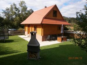 une cabane en rondins avec une bouche de feu dans la cour dans l'établissement Drevenica Silvia, à Liptovský Mikuláš