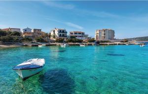 una barca seduta in acqua vicino a una spiaggia di Villa Ivan a Rogoznica (Rogosnizza)