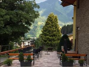 een patio met banken en een kerstboom en bergen bij Landhaus Marlies in Zell am See