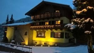 een groot gebouw met een balkon in de sneeuw bij Landhaus Marlies in Zell am See