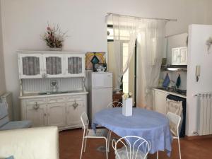 uma cozinha com uma mesa e um frigorífico branco em Casa Maria em Salerno