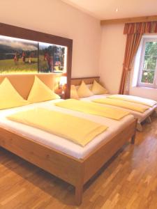 a bedroom with two beds and a large window at Gut Drasing in Krumpendorf am Wörthersee