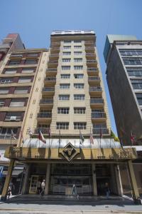 un edificio alto con banderas americanas delante de él en Hotel Versailles, en Mar del Plata