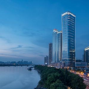 ein hohes Gebäude neben einem Fluss in einer Stadt in der Unterkunft Grand Hyatt Changsha in Changsha