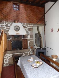 een eetkamer met een tafel en een open haard bij Casa do Forno in Valezim