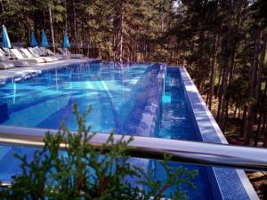 einen Pool mit blauem Wasser und Bäumen in der Unterkunft SPA Hotel Infinity Park Velingrad in Welingrad