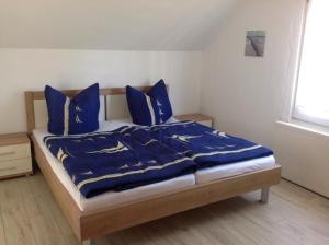 un letto con coperte blu e cuscini in una camera da letto di Haus Irma a Zingst