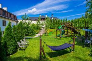 um quintal com um parque infantil com uma rede de descanso e cadeiras em Hotel Kazimierzówka em Kazimierz Dolny