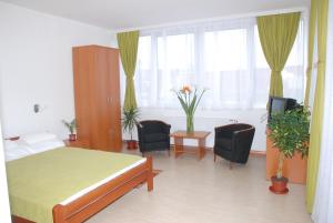 1 dormitorio con 1 cama, 2 sillas y ventana en M Garni Hotel, en Vranje