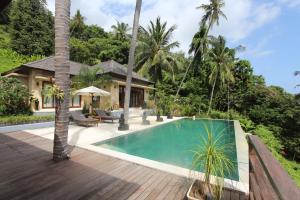 a swimming pool in front of a villa at Villa Marley in Senggigi 