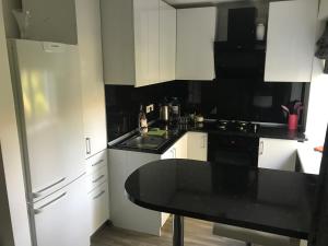 a kitchen with white cabinets and a black counter top at Fine Apartment in Jelgava