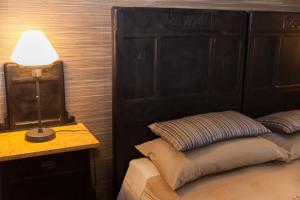 a bedroom with a bed with a black headboard and a lamp at Torino Mon Amour in Turin