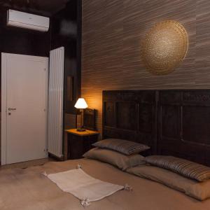 a bedroom with two beds and a lamp on the wall at Torino Mon Amour in Turin