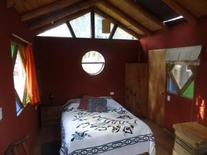 a bedroom with a bed in a room with a window at Cabanas Curi-Huapi in Isla Negra