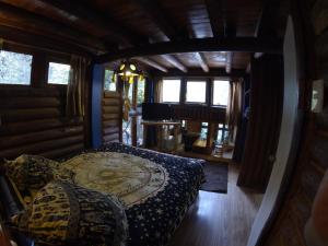 a bedroom in a log cabin with a bed in it at Cabanas Curi-Huapi in Isla Negra