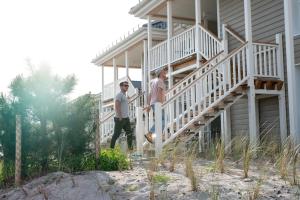 zwei Männer, die die Treppe eines Hauses hinaufgehen in der Unterkunft Beach Apartments Heiligenhafen in Heiligenhafen