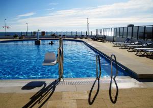 una piscina en la parte superior de un edificio con sillas en Parque de Campismo Orbitur Canidelo, en Vila Nova de Gaia