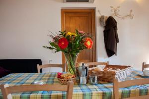 un tavolo con un vaso di fiori e un cesto di pane di Agriturismo Fontetrilla a Orbetello