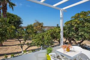 - une vue sur la plage depuis la terrasse dotée d'une table et de chaises dans l'établissement Fragos Apartments, à Santa Maria