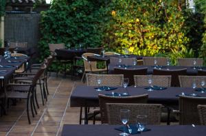 a row of tables and chairs at a restaurant at L'Argolla Hotel-Pizzeria in Santa Coloma de Farners