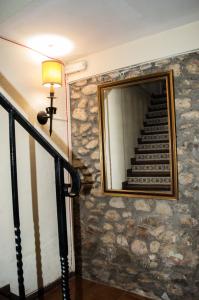 a mirror on a stone wall next to a staircase at L'Argolla Hotel-Pizzeria in Santa Coloma de Farners