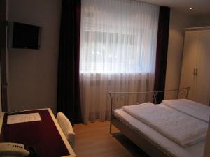 een slaapkamer met een bed voor een raam bij Hotel Barbarina in Tübingen