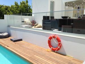 a red life preserver sitting on the side of a swimming pool at Casa do Joaquim da Praia in Nazaré