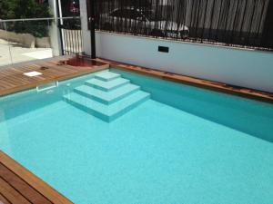 a swimming pool with blue water and stairs in it at Casa do Joaquim da Praia in Nazaré