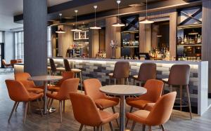 un restaurante con mesas y sillas y un bar en Leonardo Hotel Nottingham en Nottingham