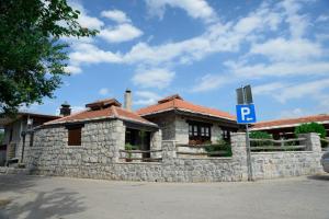 un bâtiment en pierre avec un panneau de stationnement en face de celui-ci dans l'établissement Stara Hercegovina, à Trebinje