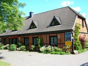 een bruin gebouw met een zwart dak en bloemen bij Altes Zollhaus am Klinikum in Lübeck