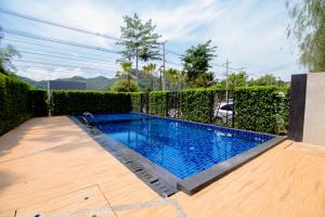 uma piscina num quintal com um deque de madeira em Fortune D Plus Hotel Khaoyai em Mu Si