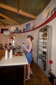 a woman standing in a kitchen holding a glass of wine at Art Tower in Vratimov