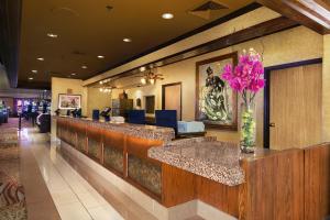 a lobby with a bar with purple flowers in a vase at Arizona Charlie's Decatur in Las Vegas