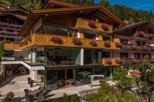 een gebouw met een balkon met bloemen erop bij Hotel Garnì Gardena - Appartments in Santa Cristina in Val Gardena