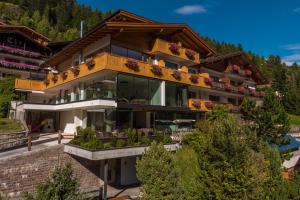 een huis in de bergen met een balkon bij Hotel Garnì Gardena - Appartments in Santa Cristina in Val Gardena