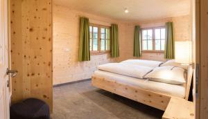 een slaapkamer met een bed in een houten kamer bij Alpenchalets Mair in Sesto