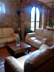 sala de estar con sofás de cuero y mesa de centro en Case Cordovani, en Magliano in Toscana