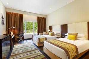 Habitación de hotel con 2 camas y escritorio en Gateway Nashik, en Nashik