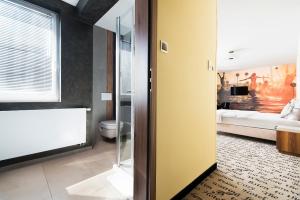 a bathroom with a yellow wall and a bedroom at Hotel Piano in Lublin