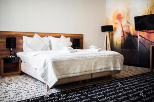 a bedroom with a large bed with white pillows at Hotel Piano in Lublin