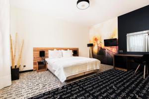 a bedroom with a large white bed and a desk at Hotel Piano in Lublin