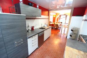 a kitchen with red walls and stainless steel appliances at La Maison Rapin in Valloire