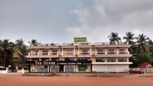 a building with a sign on top of it at Ocean Crest Hotel in Colva