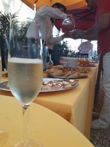 Un groupe de personnes autour d'une table avec de la nourriture dans l'établissement Hotel Ville Bianchi, à Grado