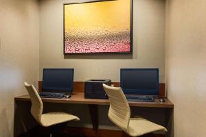 twee computers op een bureau met twee stoelen bij Hyatt Place Seattle Downtown in Seattle