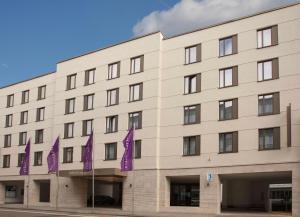 un bâtiment avec des drapeaux violets devant lui dans l'établissement Mercure Hotel Wiesbaden City, à Wiesbaden