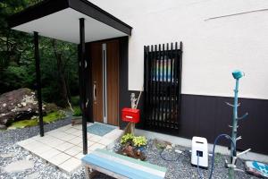 a house with a black gate and a bench at Midorian in Nikko